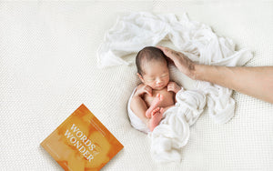 A baby lying down with words of wonder book